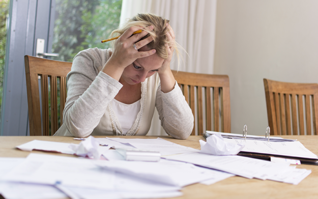 debt-relief-image A woman sites a a table with all of her bills in front of her, frustrated with her hands on her head letting you know that Sttorney Lawyer Shane Zisman specializes in Corpoerate and personal bankruptcy filing and consulting.