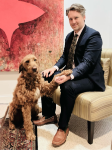shane-rufus Lawyer Attorney and Bankruptcy expert Shane Zisman sitting in a chair in his office with his dog Rufus